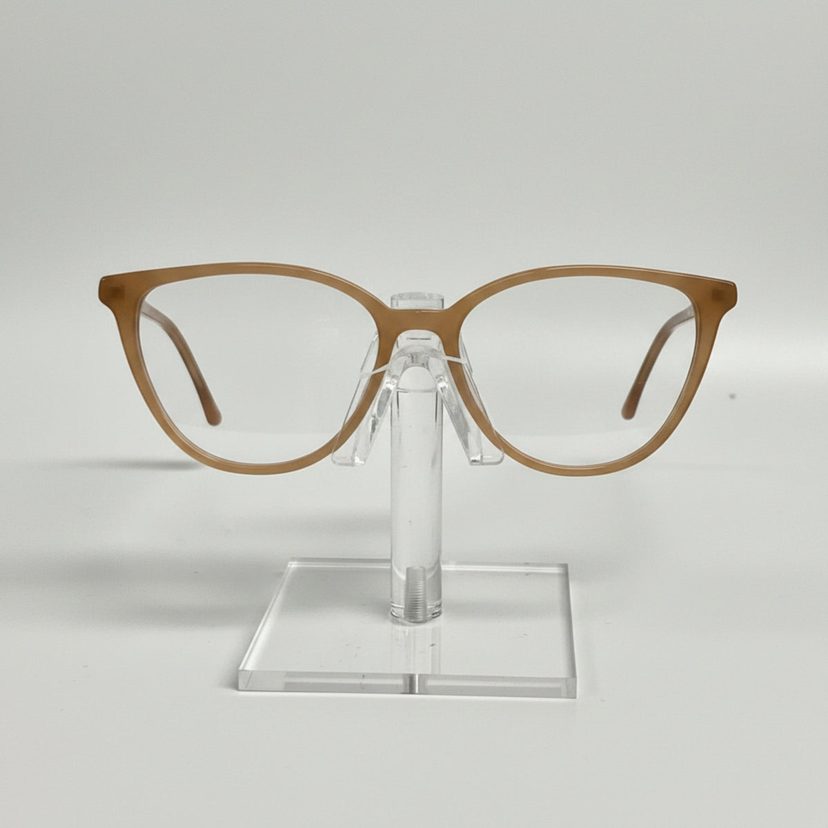 Brown eyeglasses on a clear stand against a white background