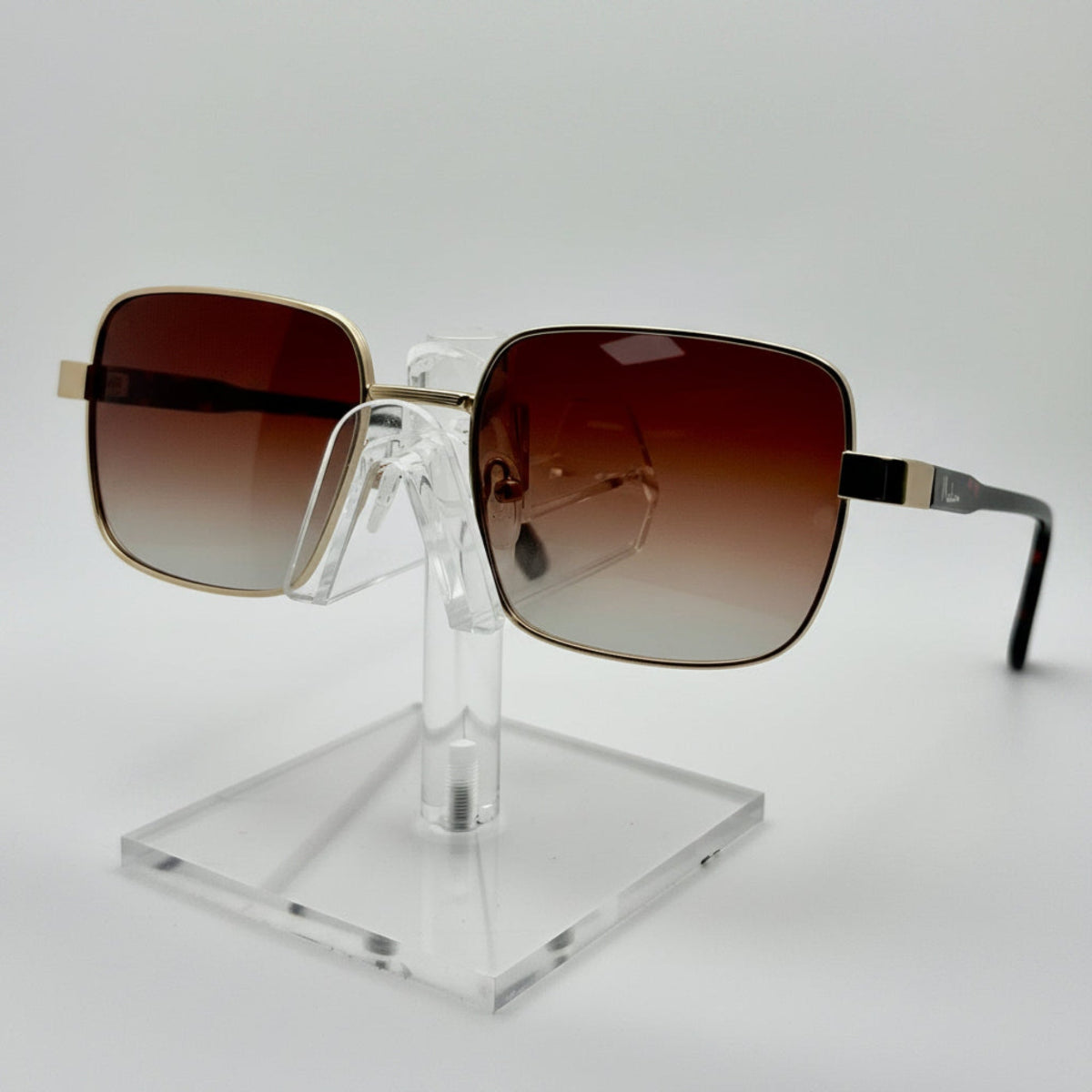 Sunglasses on a clear stand against a white background