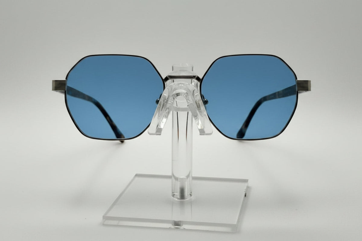 Blue sunglasses on a clear stand against a white background