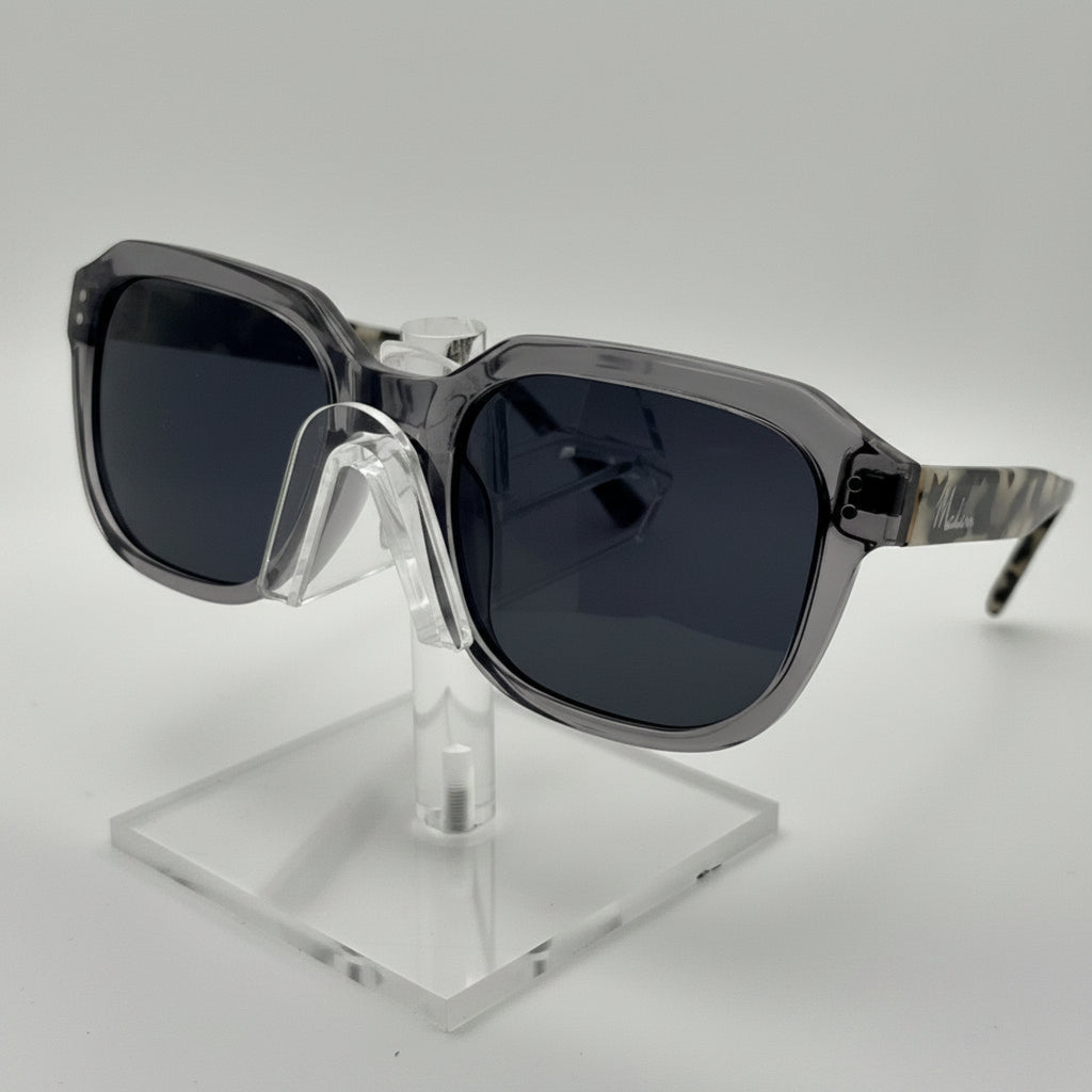 Sunglasses on a clear stand against a white background