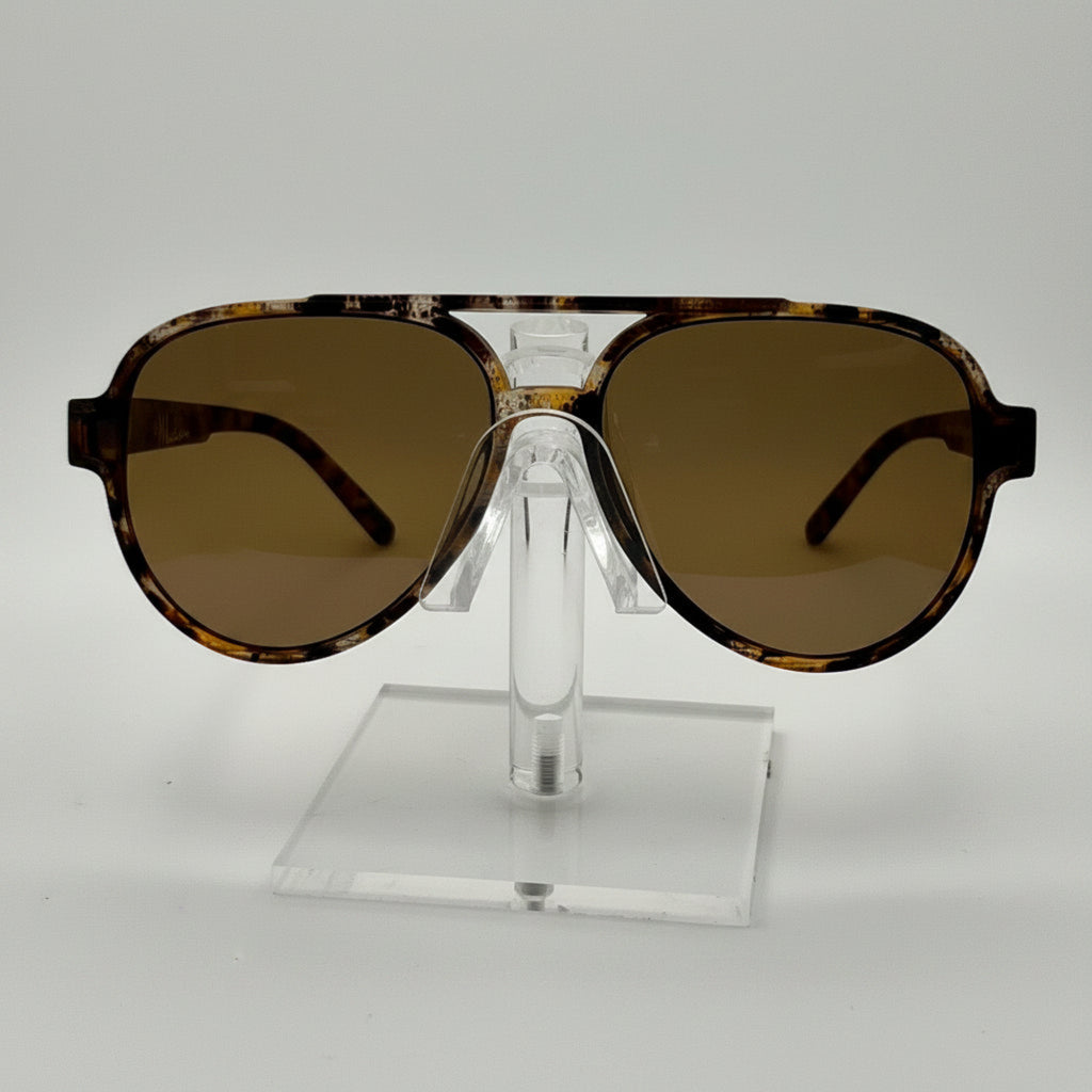 A pair of oversized aviator-style sunglasses with a tortoiseshell patterned frame and brown tinted lenses, displayed on a clear acrylic stand against a white background.
