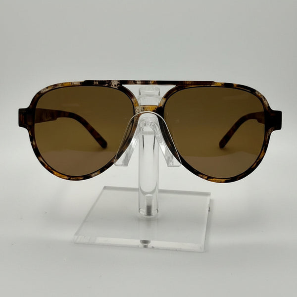 A pair of oversized aviator-style sunglasses with a tortoiseshell patterned frame and brown tinted lenses, displayed on a clear acrylic stand against a white background.