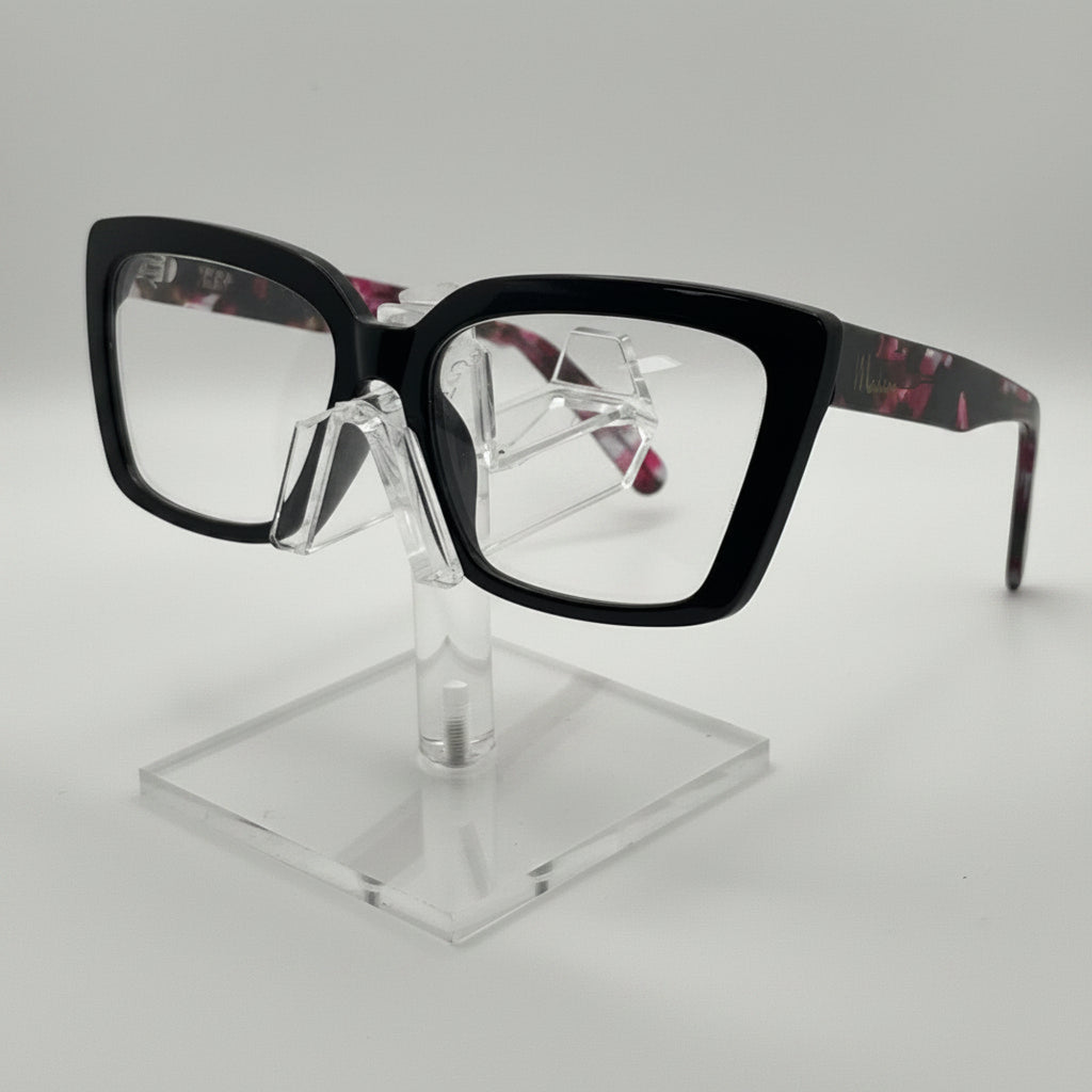 Black square eyeglasses with a tortoiseshell pattern on the temples, displayed on a clear acrylic stand against a light gray background.