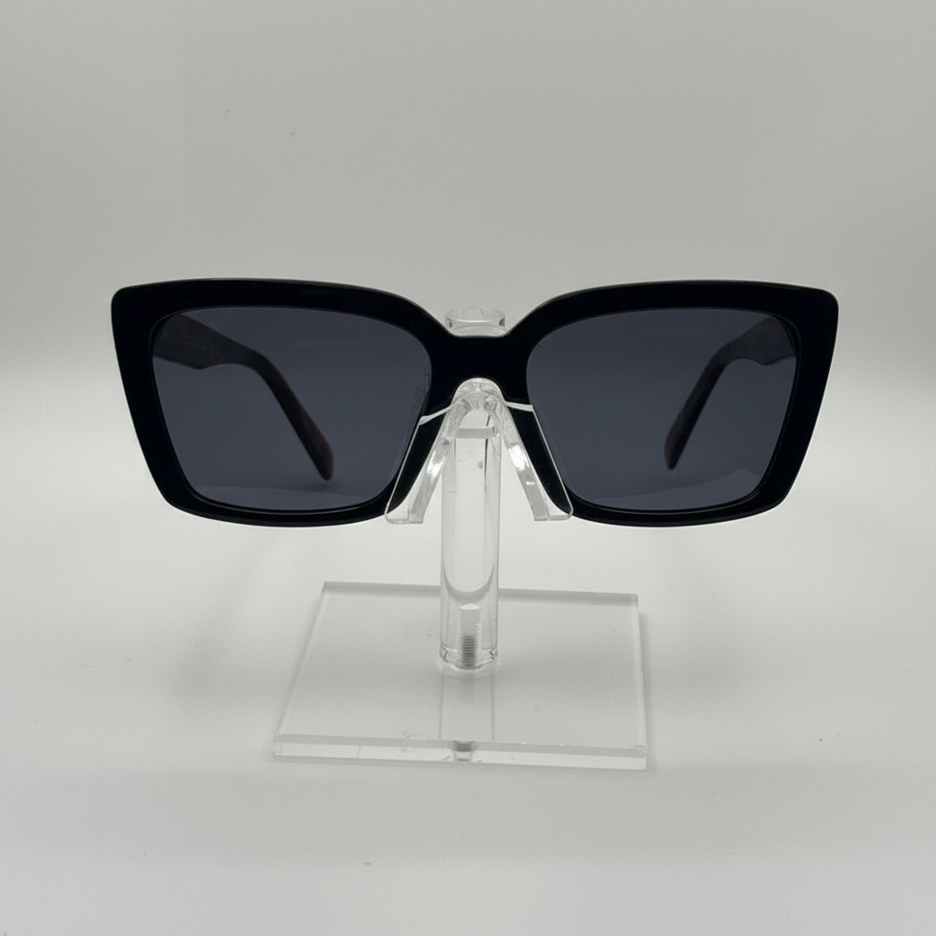 Black square sunglasses with dark lenses displayed on a clear acrylic stand against a light gray background.