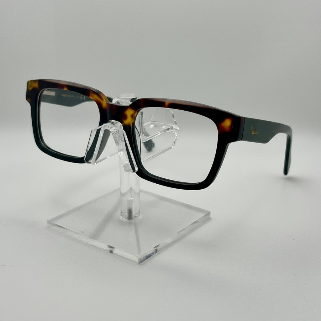 Rectangular eyeglasses with a glossy black and tortoiseshell acetate frame, displayed on a clear acrylic stand against a light gray background.