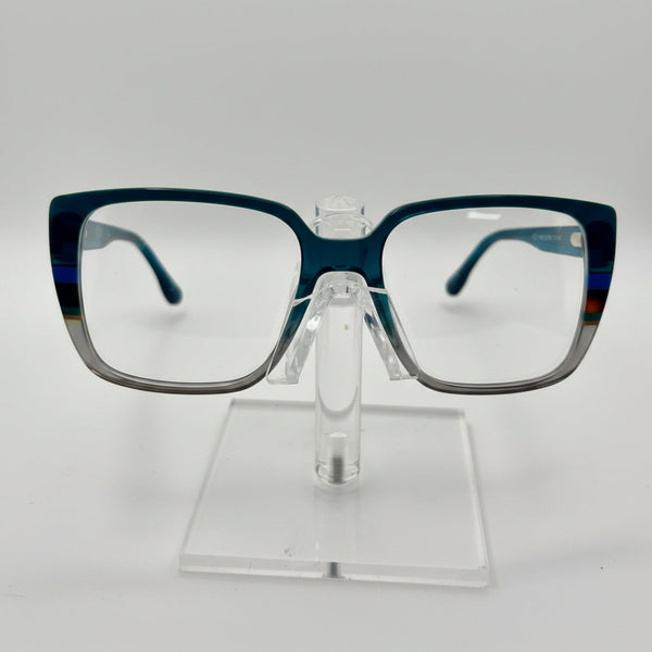 Rectangular eyeglasses with a translucent dark blue acetate frame and clear lenses, displayed on a clear acrylic stand against a white background.