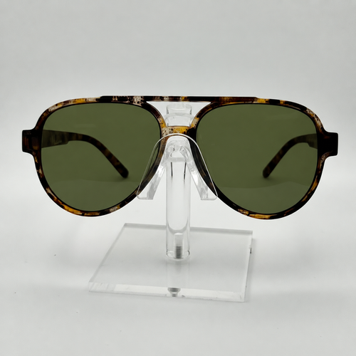 Tortoiseshell aviator sunglasses with dark green lenses, displayed on a clear acrylic stand against a light gray background.