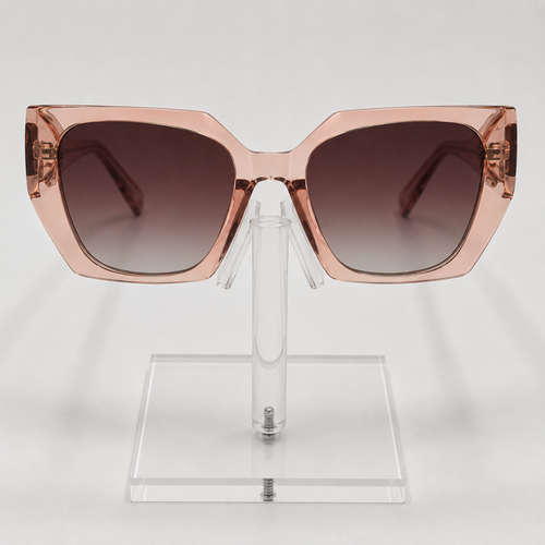 Oversized square sunglasses with a translucent rose gold frame and dark brown gradient lenses, displayed on a clear acrylic stand against a light gray background.
