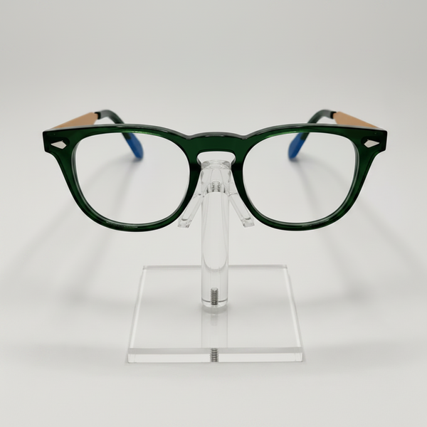 Dark green acetate eyeglass frames with light wood-look temples and blue temple tips, displayed on a clear acrylic stand against a light gray background.