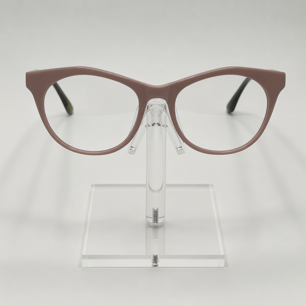A pair of cat-eye eyeglasses with a matte taupe-brown frame, displayed on a clear acrylic stand against a light gray background.