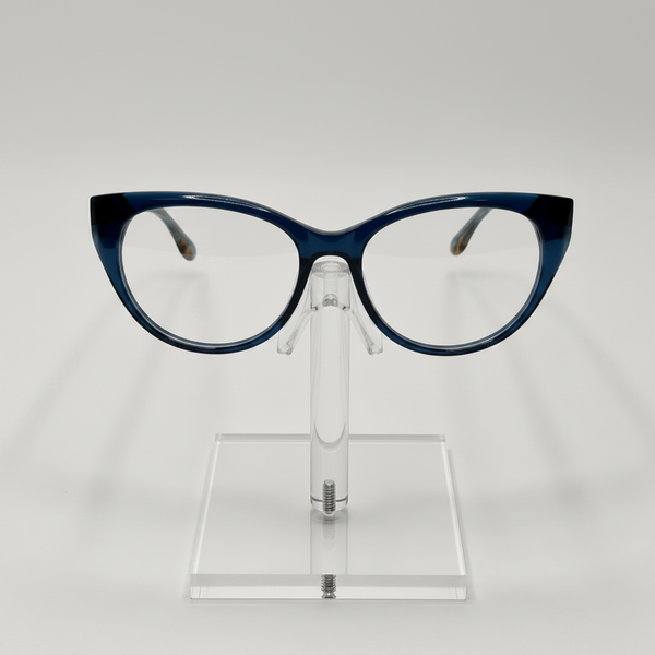 Crazy cat-eye eyeglasses with a dark blue acetate frame, displayed on a clear acrylic stand against a light gray background.
