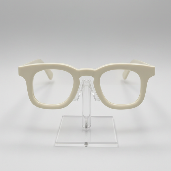 Cream-colored thick-rimmed eyeglasses displayed on a clear acrylic stand against a light gray background.
